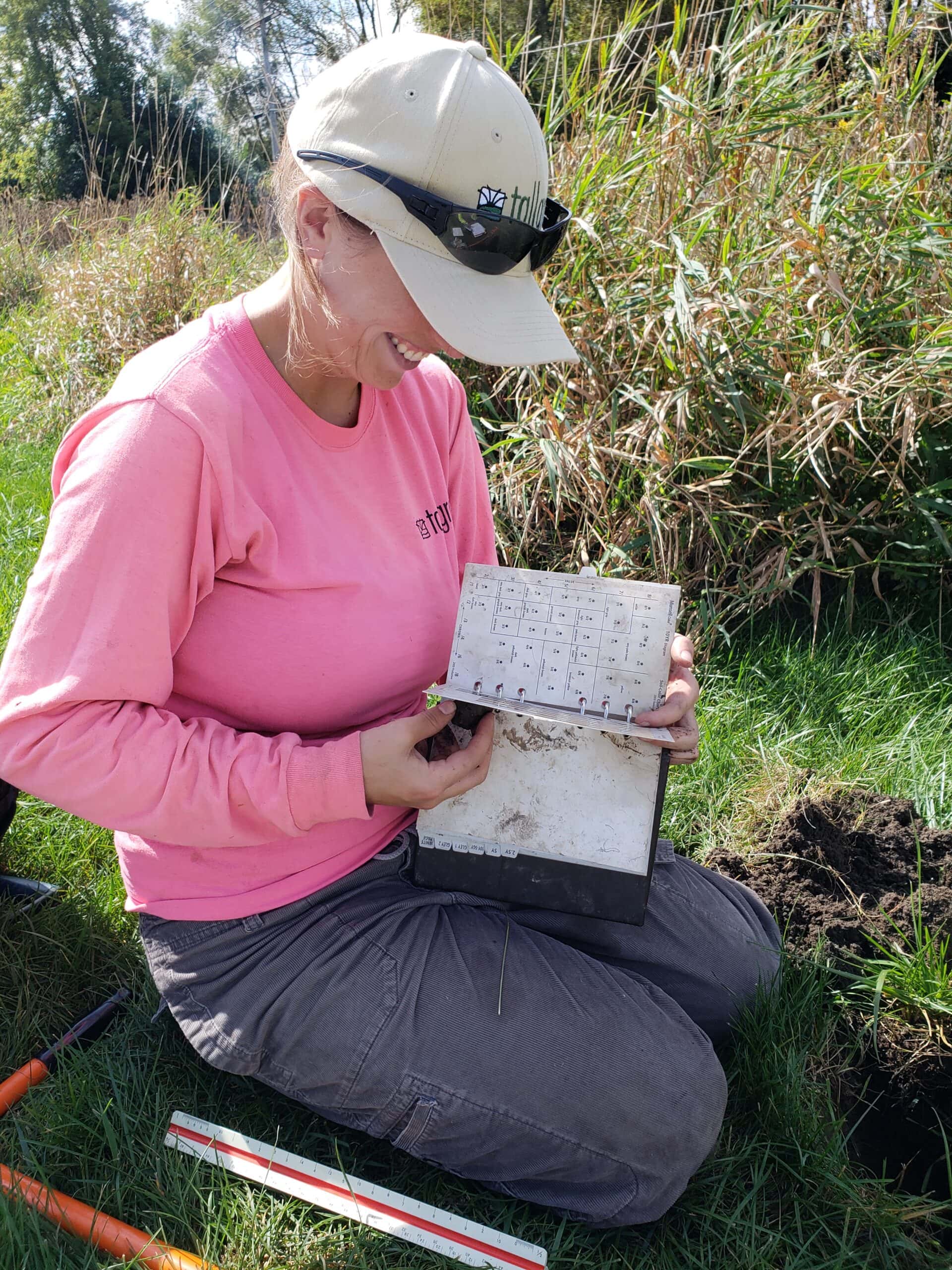 Conservationist in grasslands with notebook and tools